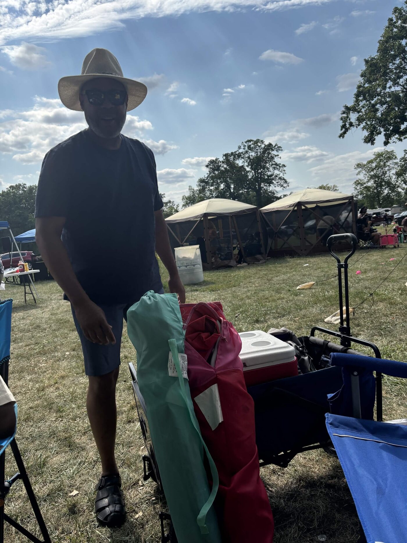 Family member standing by chairs and cookout supplies at the park