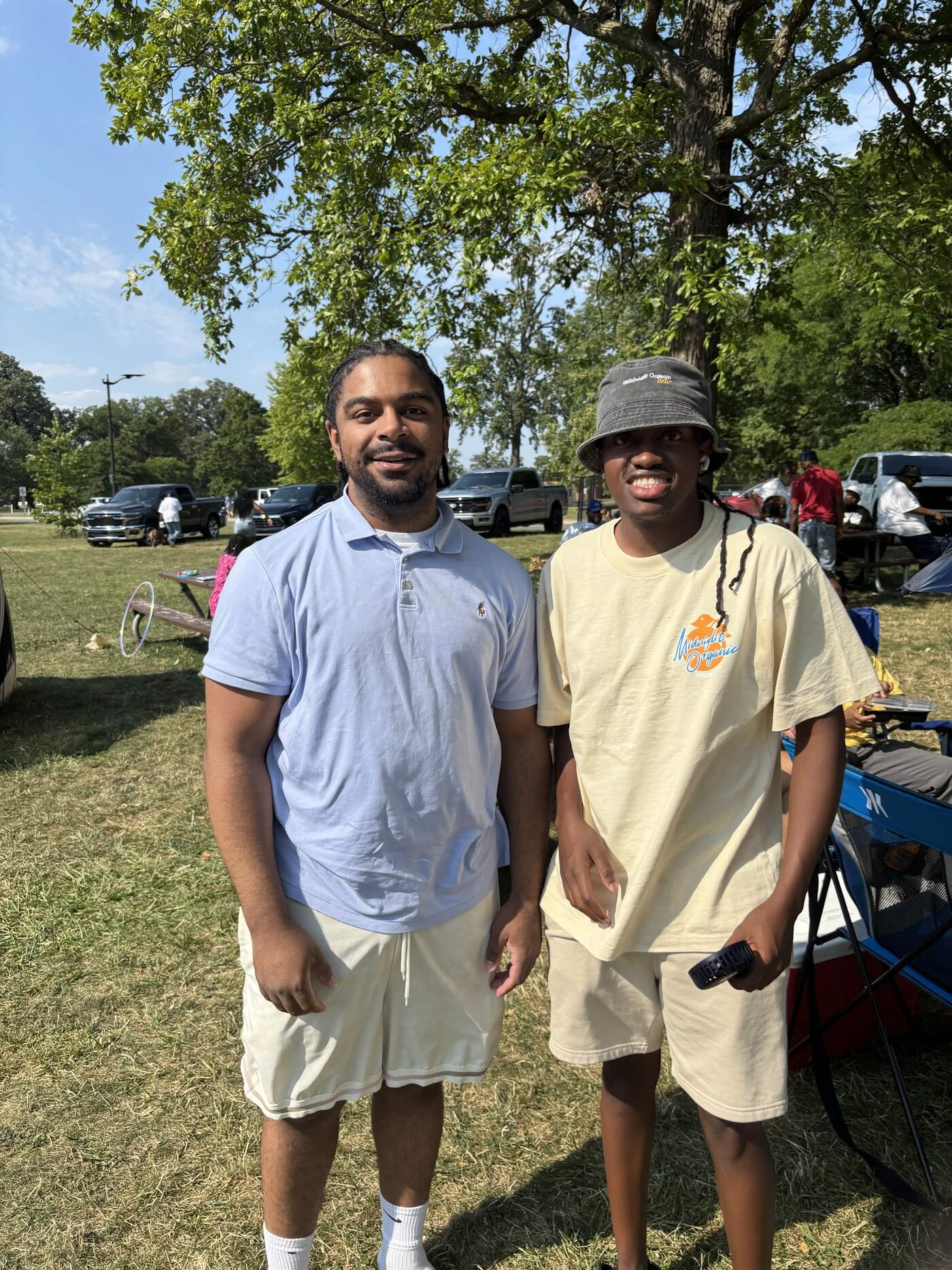 Two family members standing together under a tree at the cookout