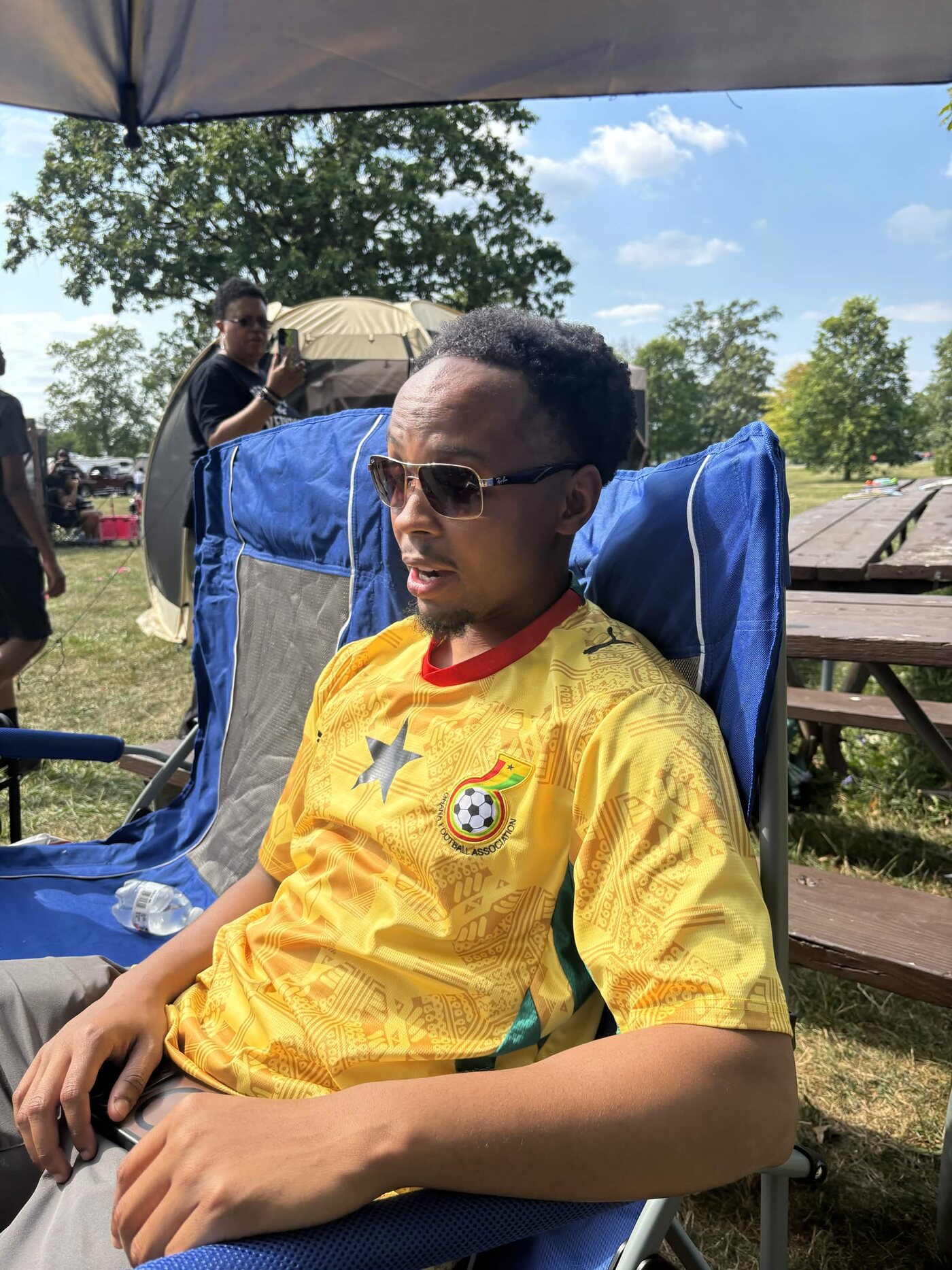 Family member sitting in a blue chair wearing a yellow jersey